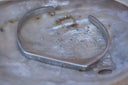 Alternate view: silver-tone open cuff with an angular flattened front and curved sides.