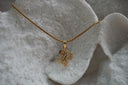 Gold-tone necklace with a ridged, dotted cactus pendant on a close-linked chain.