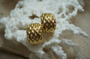Alternate view: broad open gold-tone hoop earrings with a repeating diamond-shaped surface pattern.