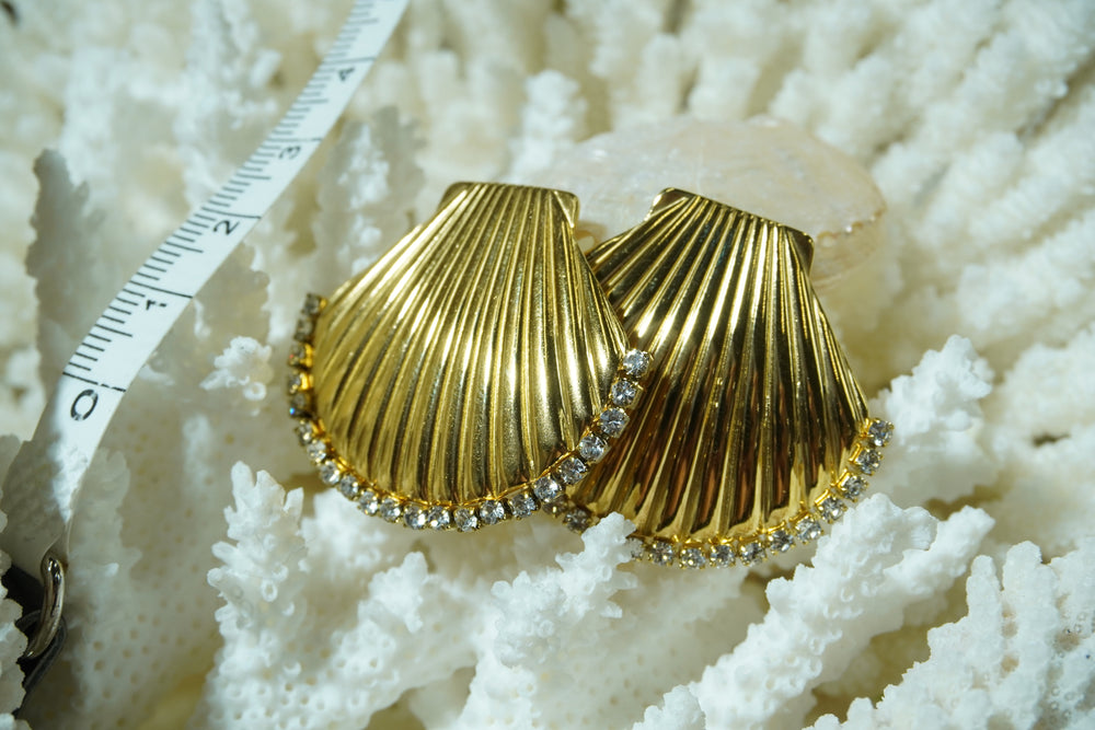 Alternate view: gold-tone scallop-shell stud earrings with radiating ridges and clear accents along the curved edge.