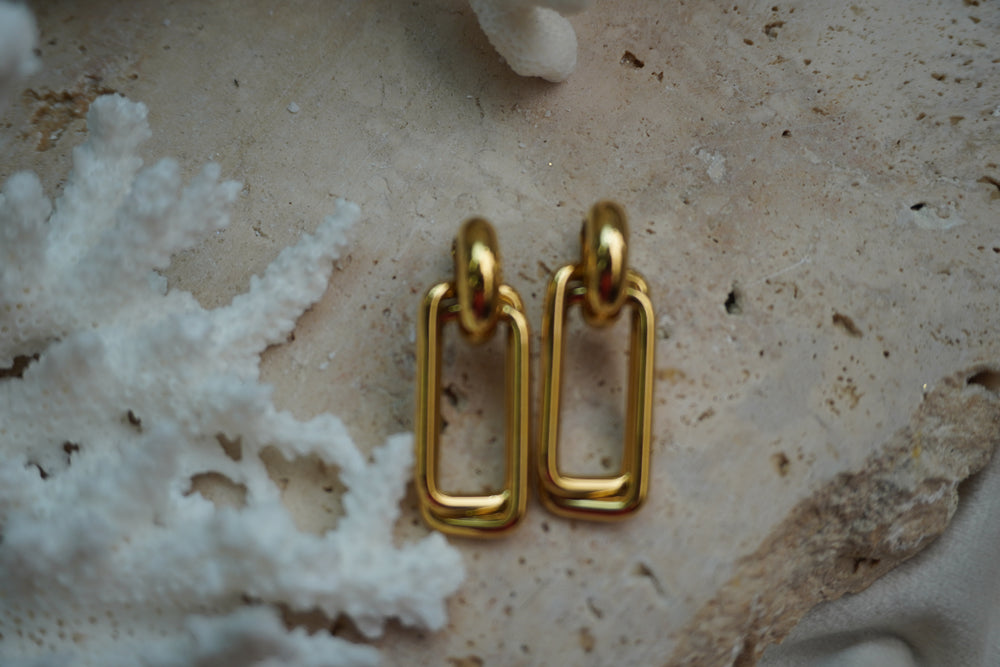 Gold-tone drop earrings with nested open rectangular links beneath rounded tops.