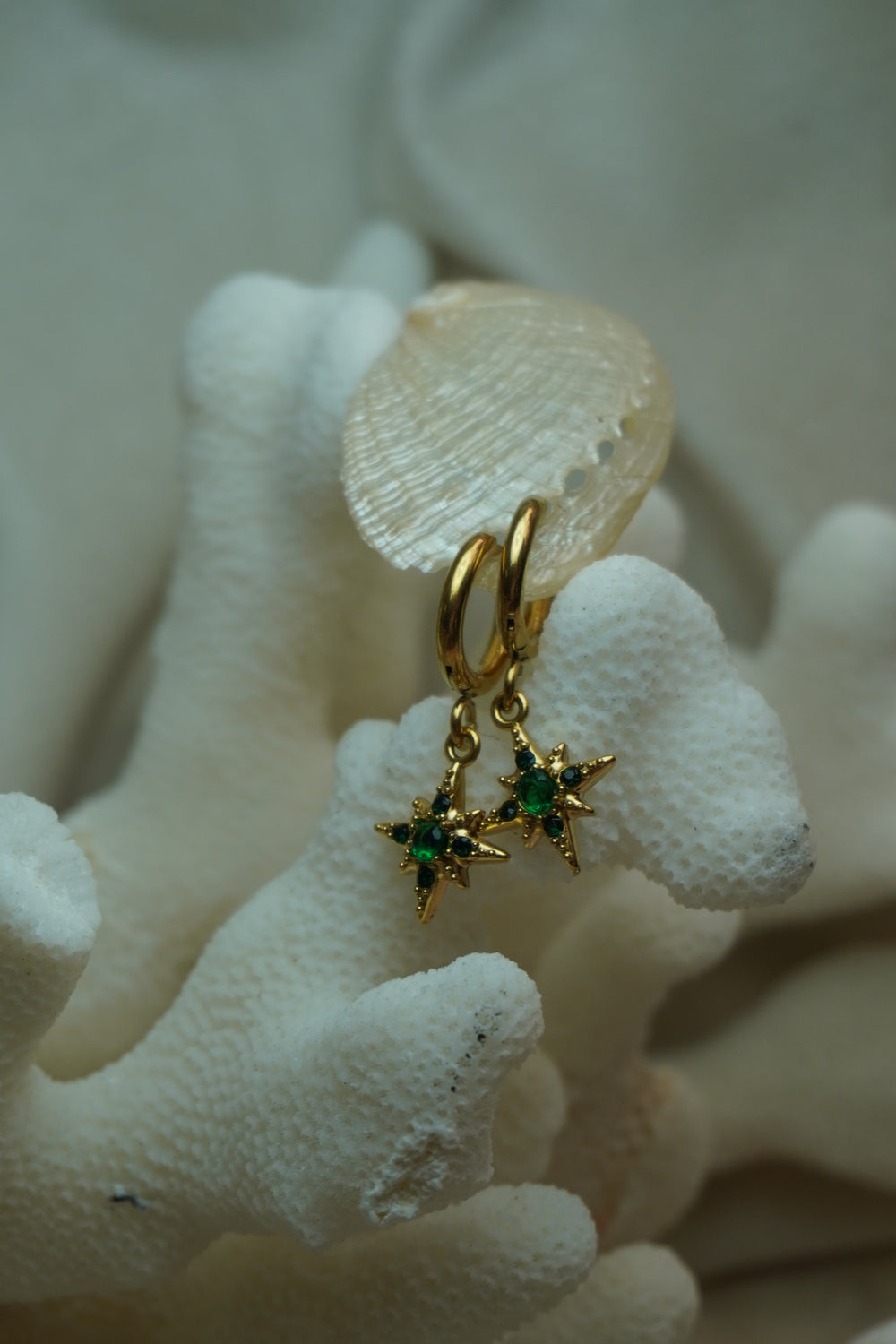 Alternate view: gold-tone hoops with pointed compass-star charms and green accents.