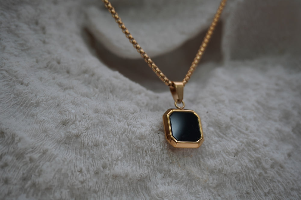 Alternate view: gold-tone chain necklace with a black square pendant, clipped corners and a smooth border.