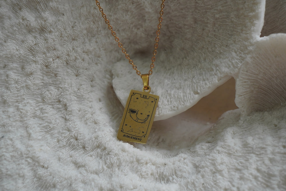 Gold-tone necklace with a rectangular Judgement pendant, curved horn, constellation lines and XX lettering.
