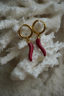 Alternate view: gold-tone hoop earrings with smooth curved red horn-shaped charms.
