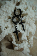 Black hoop earrings with elongated pointed cross charms.