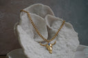 Gold-tone link necklace with a bull-skull pendant, sweeping horns and a blue oval accent.