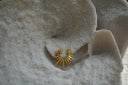 Gold-tone necklace with an open crescent-like centre and long radiating points.
