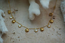 Gold-tone fine chain necklace with alternating small shell motifs and clear round accents in gold-tone borders.