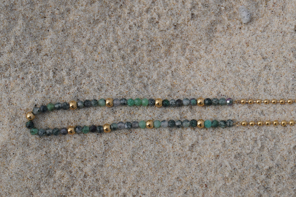 Detail view: necklace combining mottled green and grey beads with a gold-tone ball-chain section.
