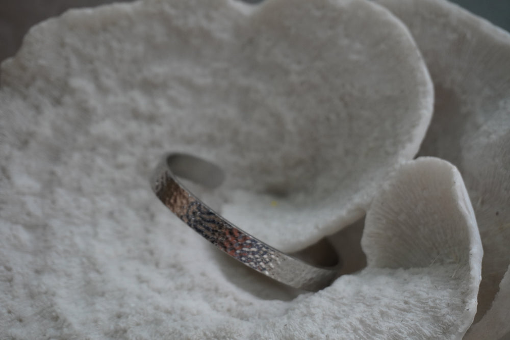 Alternate view: silver-tone narrow open cuff with a dimpled reflective surface.