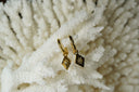 Alternate view: gold-tone hoops with diamond-shaped tile charms bearing eight-point stars and clear centre accents.
