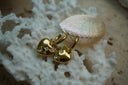 Alternate view: gold-tone hoops with rounded heart charms and scattered clear accents in square outlines.