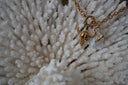 Alternate view: gold-tone necklace with horned skull, boot and pale reflective drop charms.