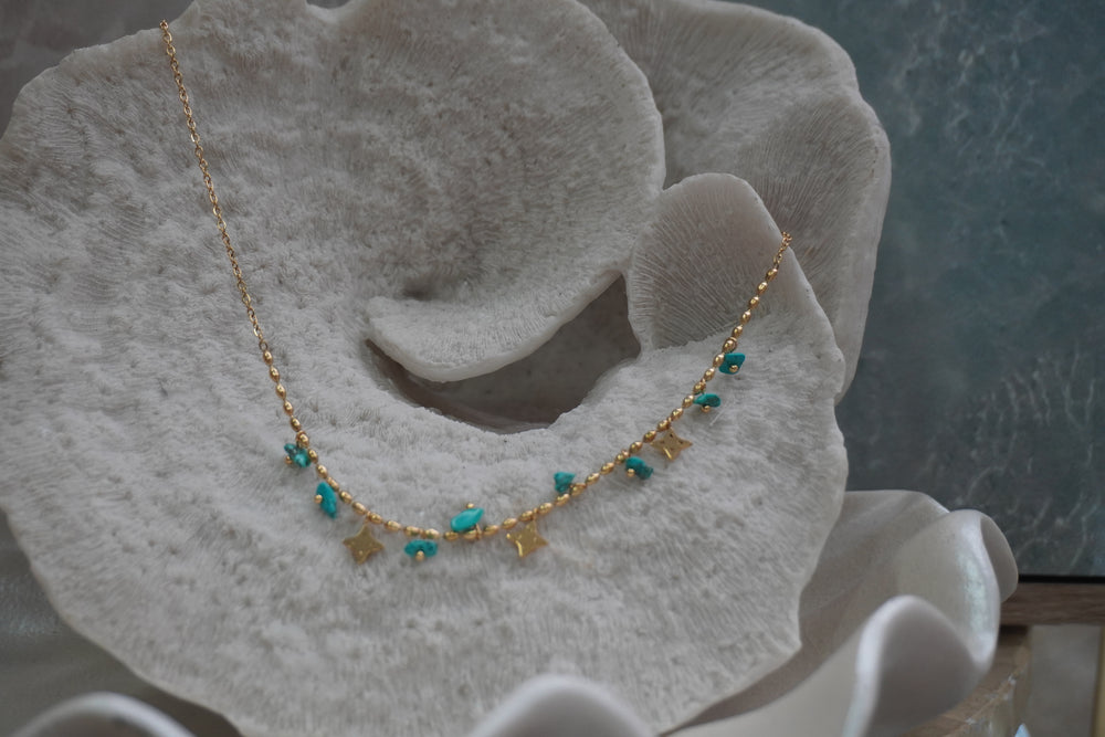 Alternate view: gold-tone necklace with oval chain details, irregular blue bead drops and four-point star charms.