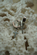 Alternate view: silver-tone broad hoop earrings with hanging plain cross charms.