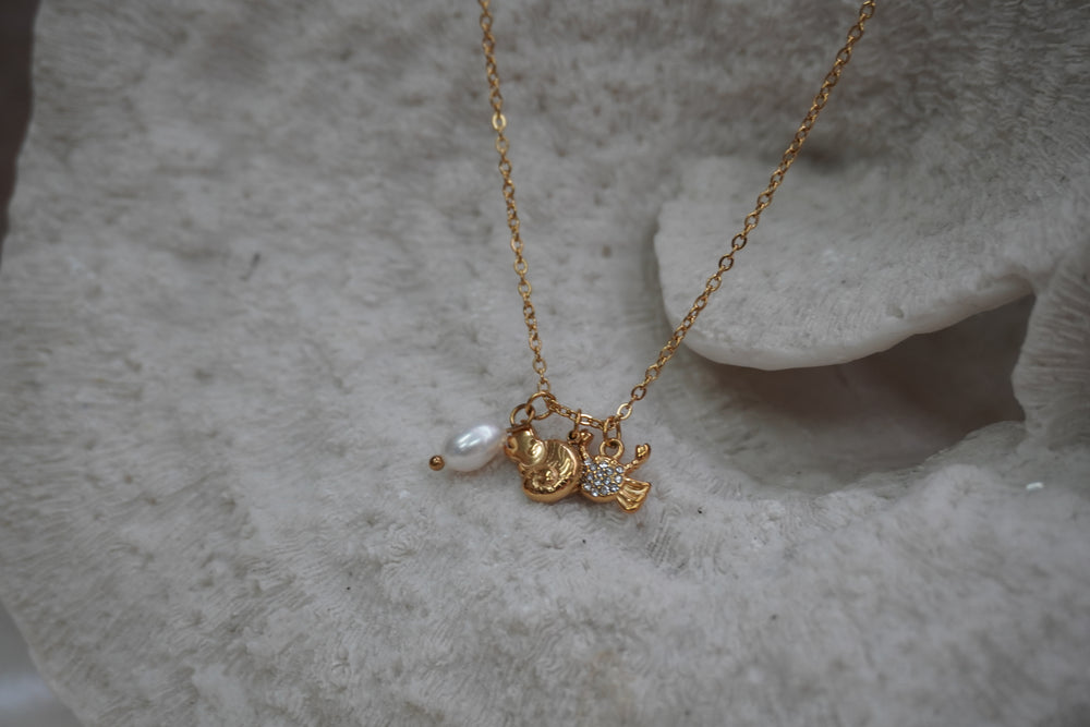 Alternate view: gold-tone chain necklace with two fish charms, clear accents and a white oval bead.