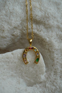 Alternate view: gold-tone necklace with a horseshoe pendant decorated with multicoloured accents in varied shapes.