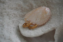 Rounded gold-tone hoop earrings covered with close-set parallel ridges.