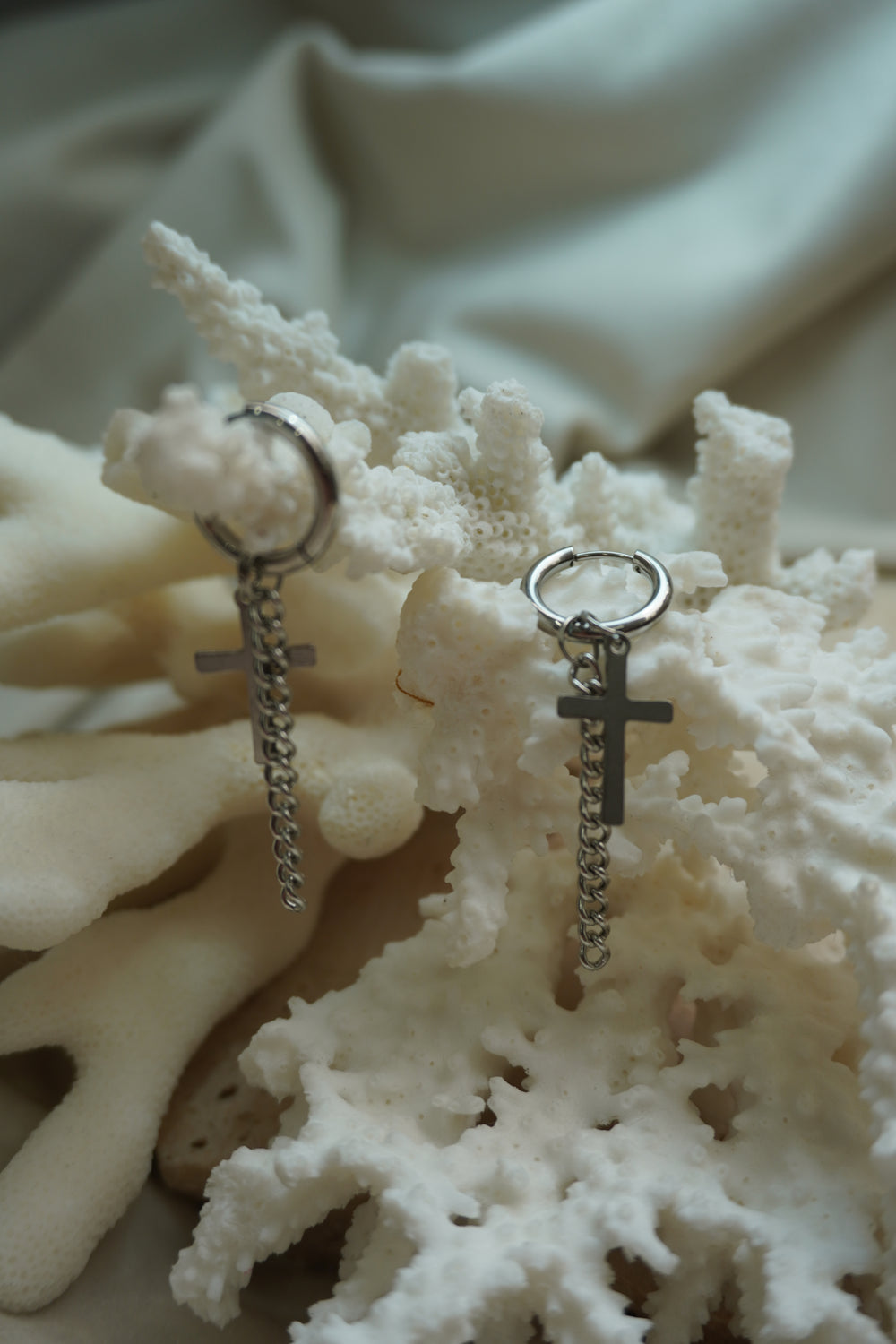 Silver-tone hoop earrings with flat cross charms and longer hanging chain drops.