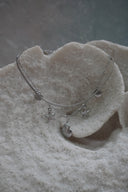 Alternate view: layered silver-tone necklace with a flat upper strand and shell and starfish charms on a fine lower chain.