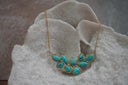 Alternate view: gold-tone chain necklace with a cluster of blue veined oval, teardrop and rounded-square centres in gold-tone borders.