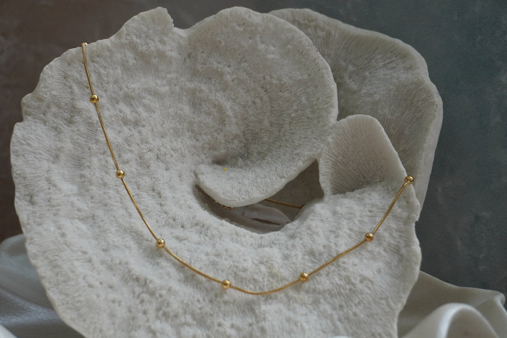Fine gold-tone necklace with evenly spaced round gold-tone beads.