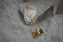 Alternate view: gold-tone earrings with elongated safety-pin silhouettes and broad curved lower sections.
