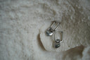 Alternate view: silver-tone rounded rectangular hoops with small hanging heart charms.