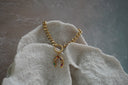 Gold-tone chain bracelet with a horseshoe charm set with multicoloured accents beneath a round connector.