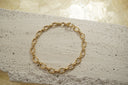Gold-tone bracelet with fine oval links, small ridged connectors and a clasp.