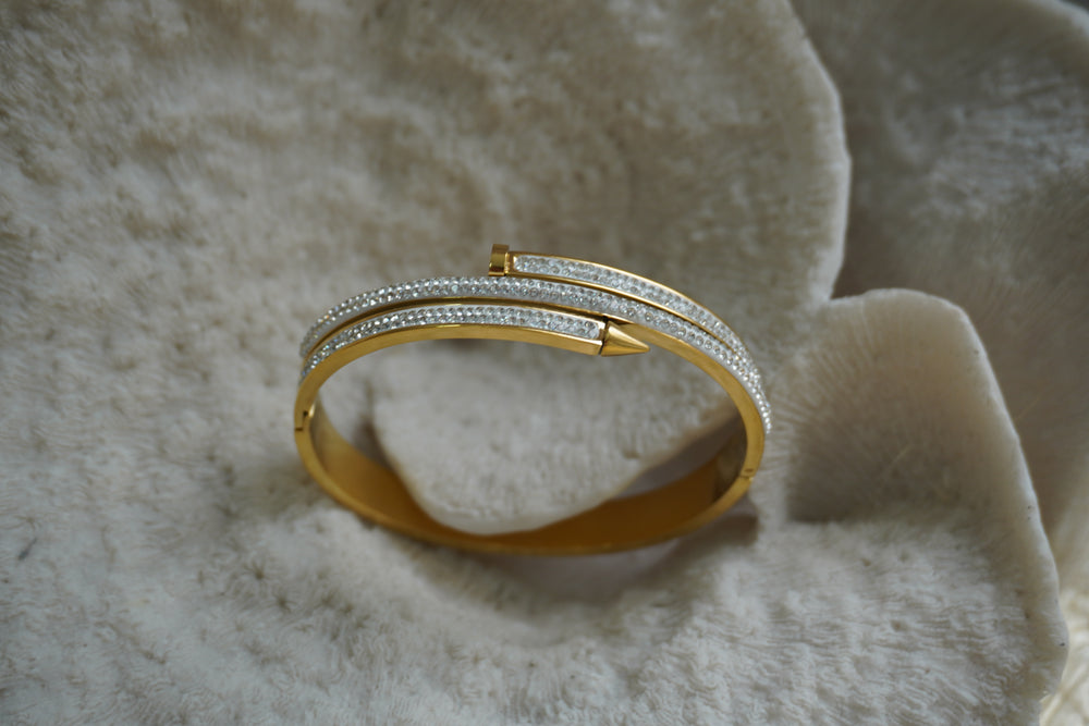 Alternate view: gold-tone hinged bangle with overlapping nail-like bars and rows of small clear accents.