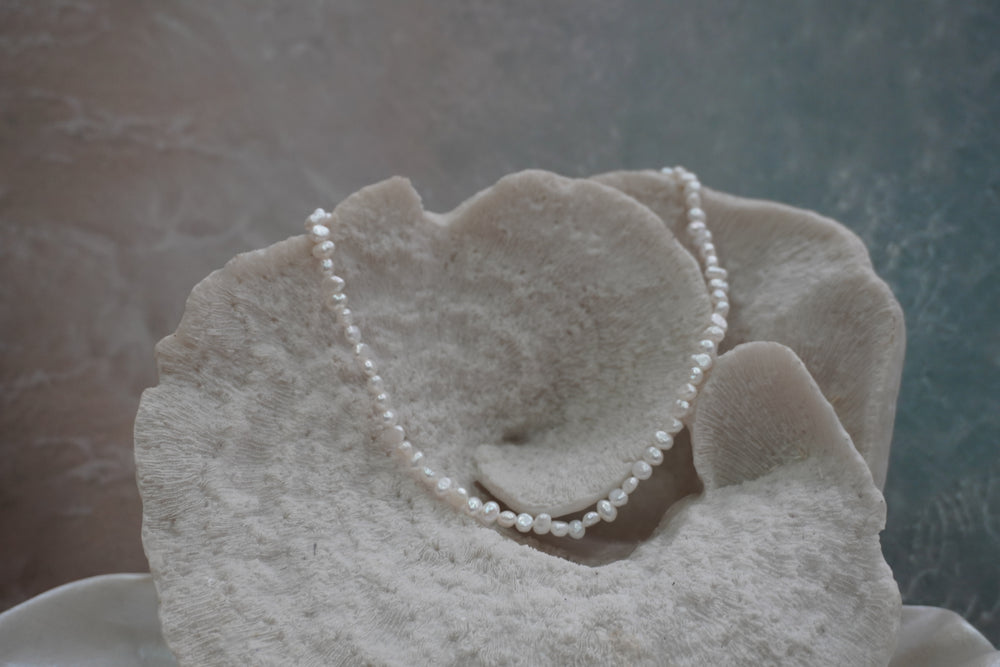 Alternate view: necklace of closely strung irregular white beads with an iridescent appearance.