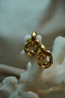 Alternate view: gold-tone earrings with overlapping textured circular links beneath smooth curved tops.