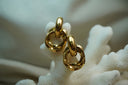 Gold-tone earrings with overlapping textured circular links beneath smooth curved tops.