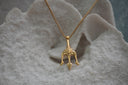 Alternate view: gold-tone chain necklace with a three-point trident pendant and a sculpted face detail.