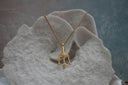 Gold-tone chain necklace with a three-point trident pendant and a sculpted face detail.