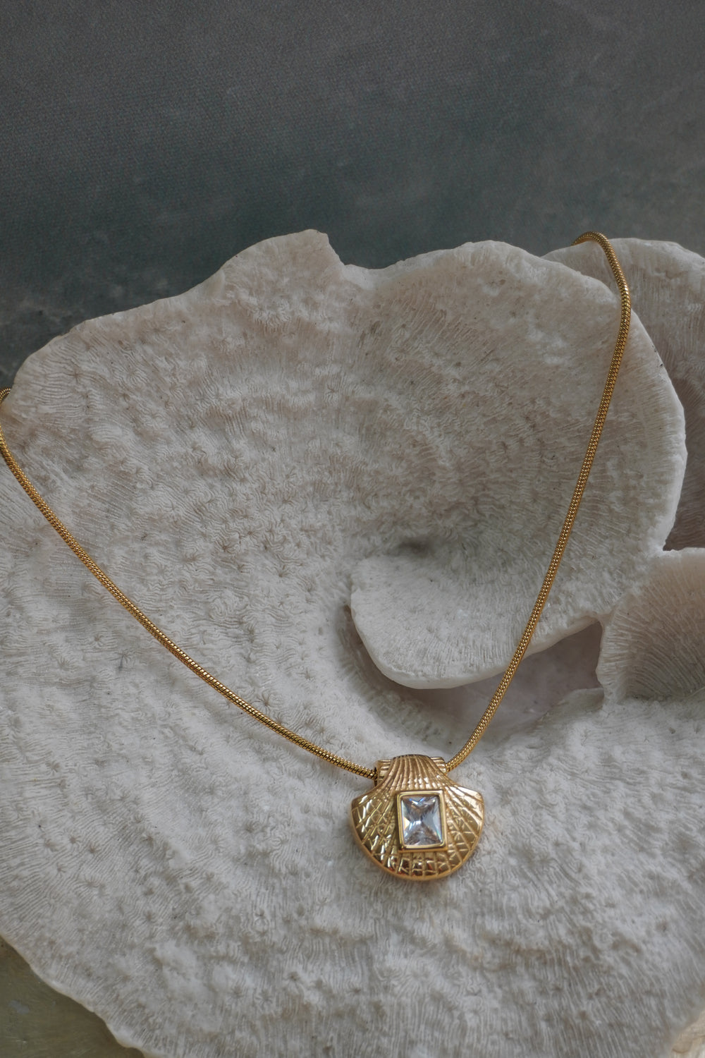 Alternate view: gold-tone necklace with a shell-shaped pendant and clear-looking rectangular centre.
