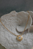 Alternate view: gold-tone necklace with a shell-shaped pendant and clear-looking rectangular centre.