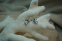 Alternate view: silver-tone cross-shaped stud earrings with round clear accents and larger teardrop accents below.