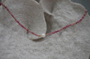 Pink beaded necklace with gold-tone accents and a white centre bead.