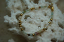 Alternate view: bracelet with pale aqua, green and white beads, gold-tone spheres and a long mottled accent.