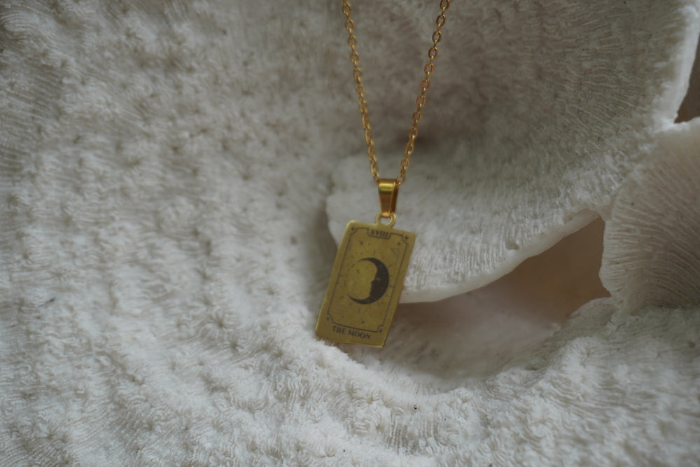 Alternate view: gold-tone necklace with a rectangular The Moon pendant, crescent face, radiating marks and XVIII lettering.