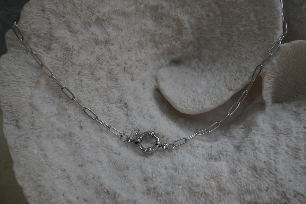 Silver-tone elongated-link necklace with a circular centre connector.