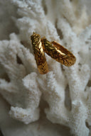 Alternate view: gold-tone hoop earrings with a raised plaited pattern of overlapping leaf-like shapes.