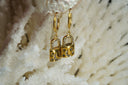 Gold-tone hoop earrings with padlock-shaped drops, moon and star motifs, and clear round accents.