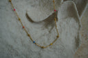 Gold-tone chain necklace with multicoloured beads and reflective gold-tone spheres.