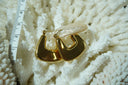 Broad gold-tone hoop earrings with flat flared faces, rounded corners and open centres.