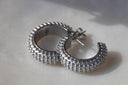 Silver-tone open hoop earrings with rows of raised rounded dots and visible posts and backs.