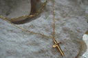 Alternate view: gold-tone layered necklace design with elongated upper links and a smooth cross pendant on a finer chain.